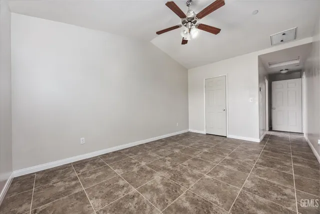an empty room with a window and a fan