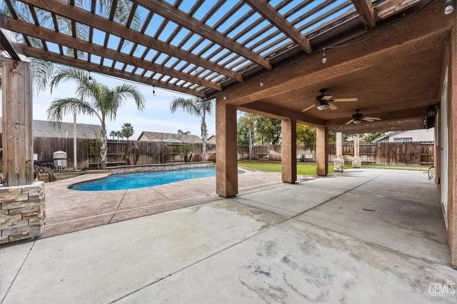 a view of a swimming pool with a chair and palm trees