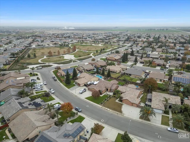 a view of a big house with a big yard and large trees