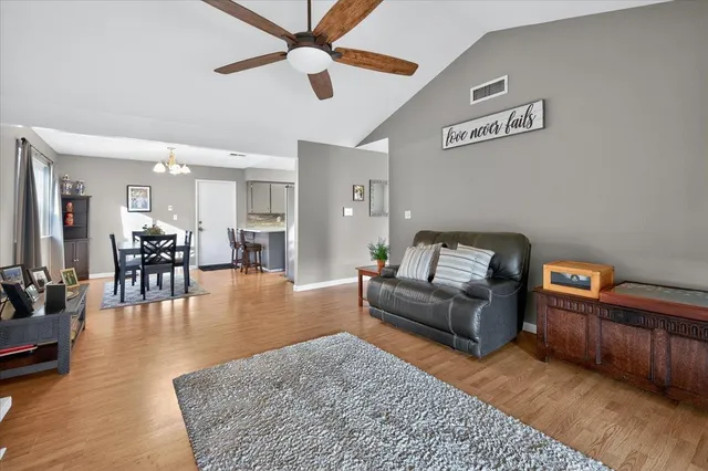 a living room with furniture and a view of kitchen