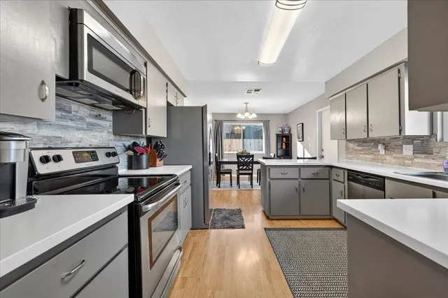 a kitchen with stainless steel appliances granite countertop a sink a stove and cabinets