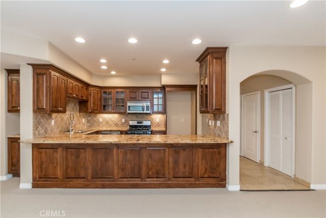 a kitchen with kitchen island granite countertop a stove and a refrigerator