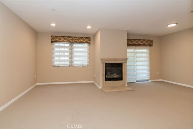 an empty room with windows and fireplace