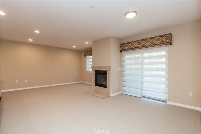 an empty room with a fireplace and entryway