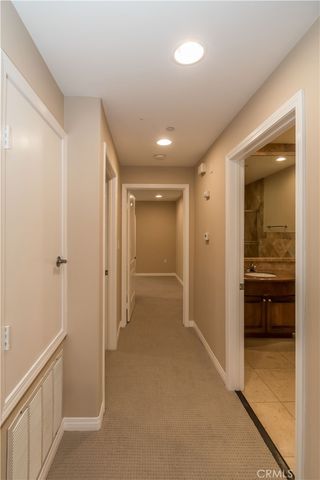 a view of a hallway with closet and bathroom