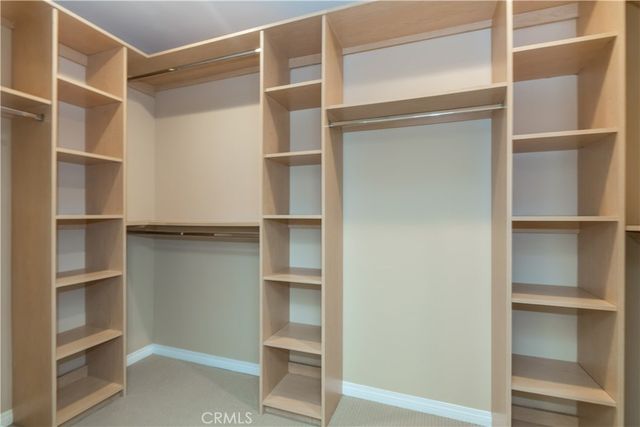 a view of walk in closet with empty racks