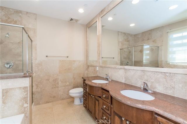 a bathroom with a double vanity sink mirror and toilet