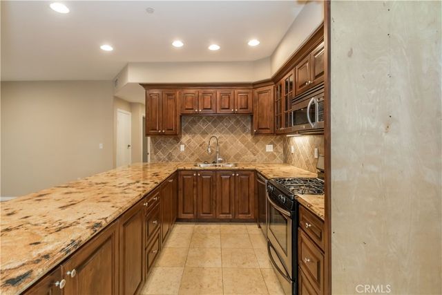 a kitchen with granite countertop sink stainless steel appliances and cabinets