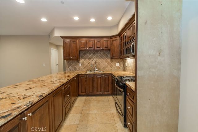 a kitchen with granite countertop a sink and a stove