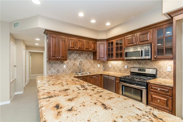 a kitchen with stainless steel appliances granite countertop a stove sink and cabinets
