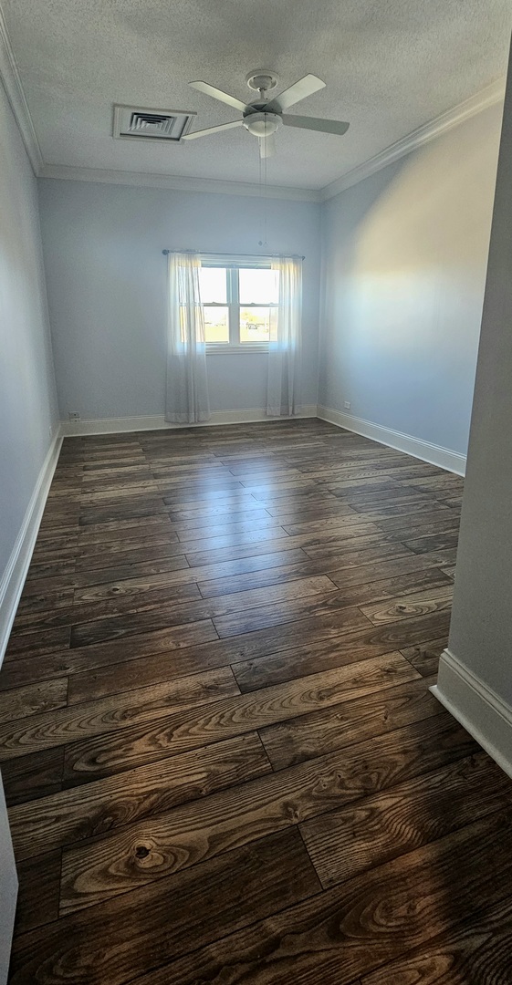 7850 West Addison Street, Unit 202 Chicago, IL 60634 - Photo 4 of 6 an empty room with wooden floor and windows