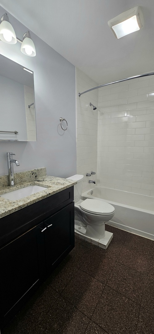7850 West Addison Street, Unit 202 Chicago, IL 60634 - Photo 5 of 6 a bathroom with a double vanity sink toilet and a bathtub
