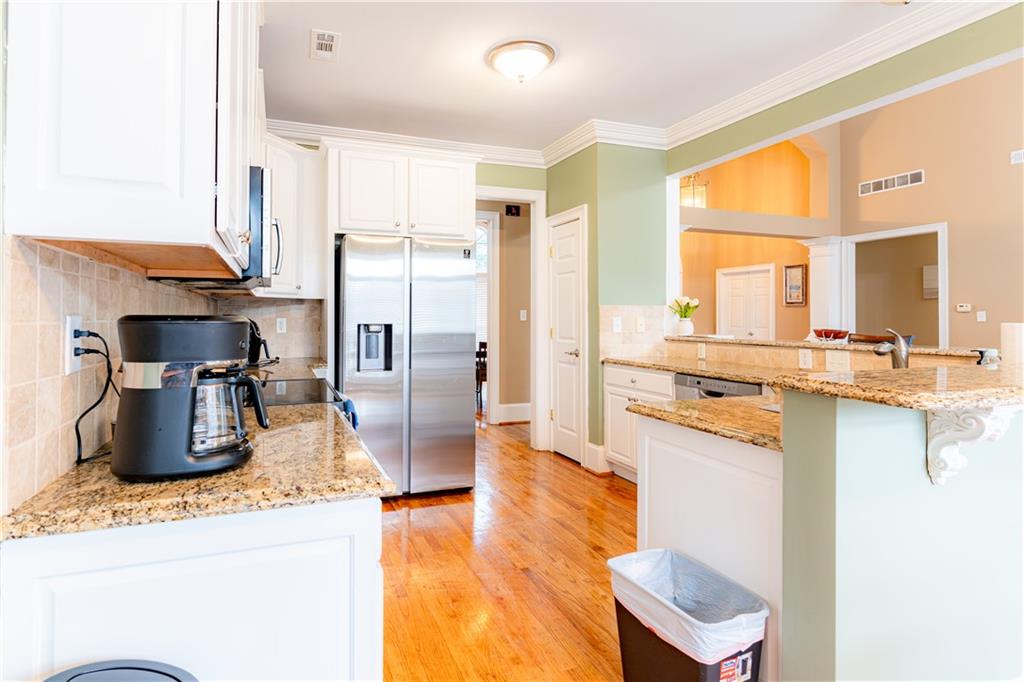 8105 Jot Em Down Road Gainesville, GA 30506 - Photo 23 of 73 a kitchen with stainless steel appliances granite countertop a sink a stove and a refrigerator