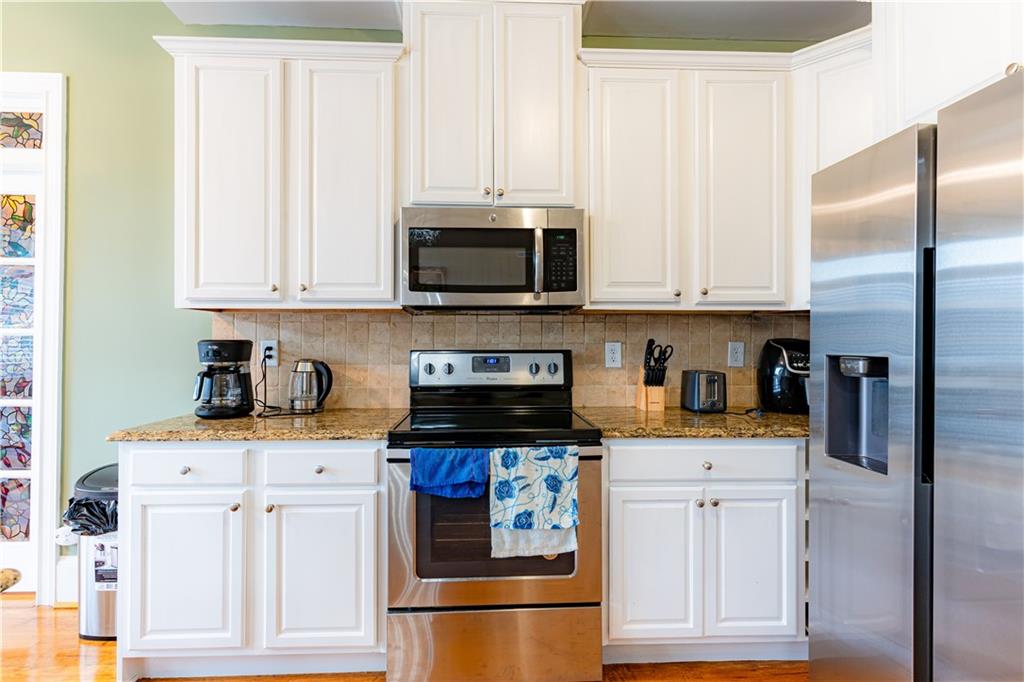 8105 Jot Em Down Road Gainesville, GA 30506 - Photo 24 of 73 a kitchen with stainless steel appliances granite countertop a refrigerator and a stove top oven