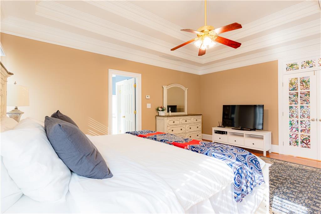 8105 Jot Em Down Road Gainesville, GA 30506 - Photo 32 of 73 a bedroom with a large bed a flat tv screen and dresser