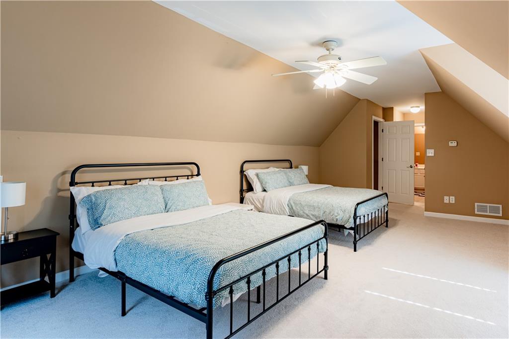 8105 Jot Em Down Road Gainesville, GA 30506 - Photo 48 of 73 a bedroom with two beds and a chandelier