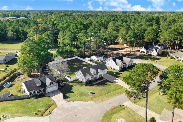 an aerial view of a house with a garden and lake view
