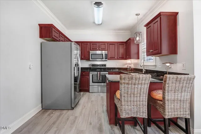 a kitchen with stainless steel appliances granite countertop a sink stove microwave and refrigerator