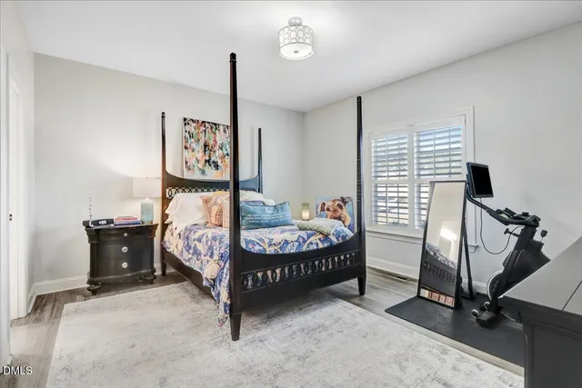 a bedroom with a bed and a flat screen tv on the dresser