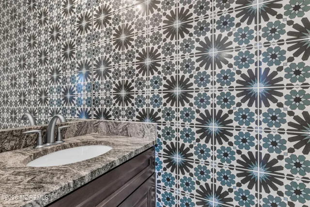 a kitchen with kitchen island a sink stainless steel appliances and chairs