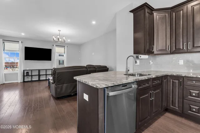 a bathroom with a granite countertop bathtub sink vanity mirror and toilet