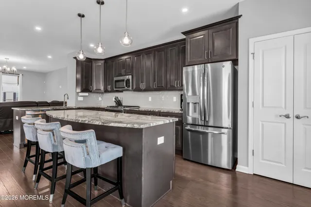an empty room with chandelier fan and windows