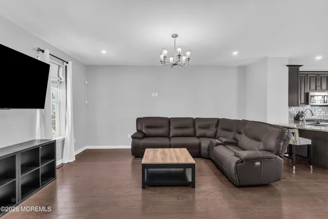 a kitchen with stainless steel appliances granite countertop a stove top oven a sink dishwasher a dining table and chairs with wooden floor