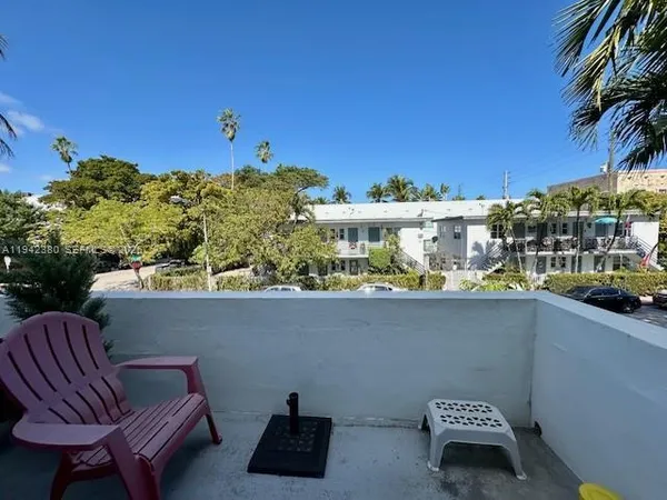 a view of a balcony with chairs and a potted plant