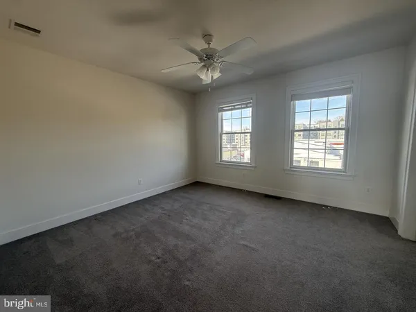 an empty room with a window and a fan
