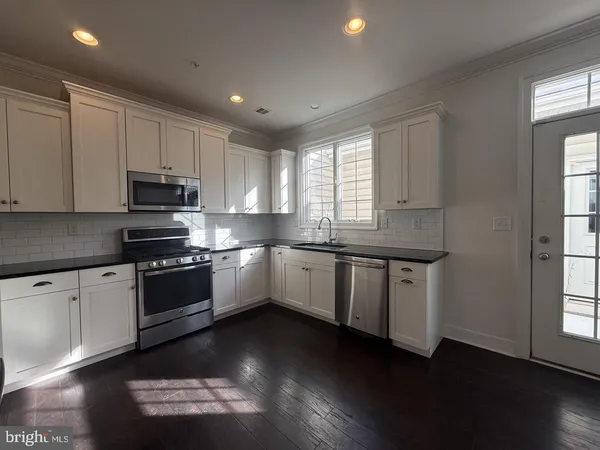 a kitchen with granite countertop cabinets stainless steel appliances and a window