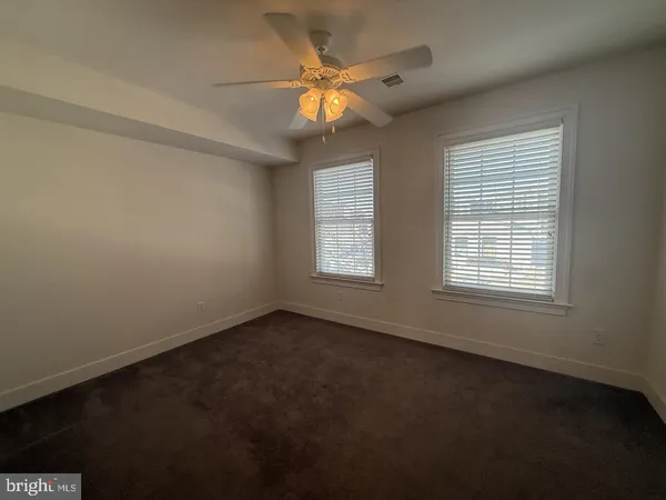 an empty room with a window and a fan