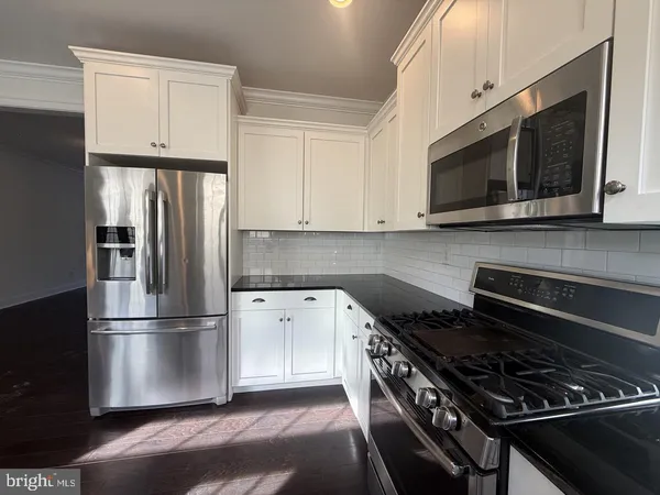 a kitchen with stainless steel appliances and white cabinets
