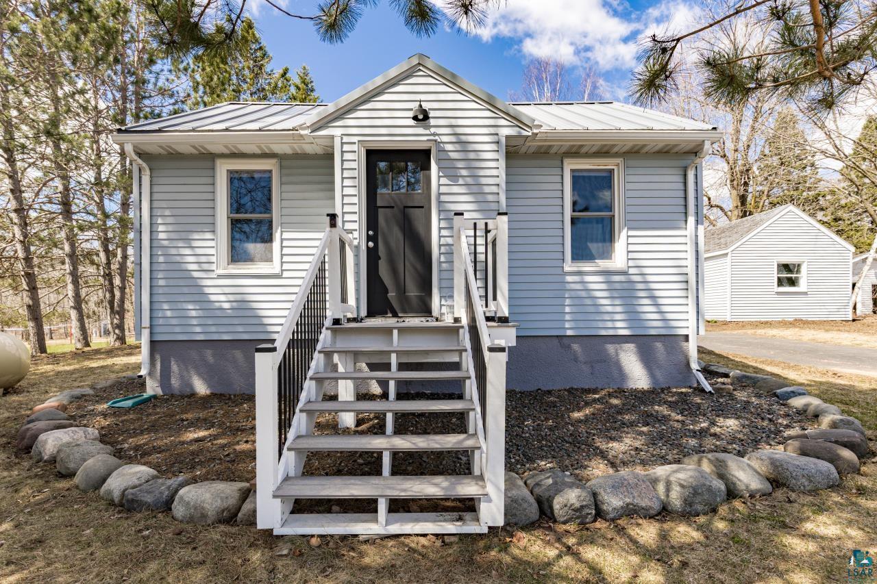 3645 Haines Road Hermantown, MN 55811 - Photo 11 of 35 Light blue horizontal siding exterior with a metal roof and an enclosed porch