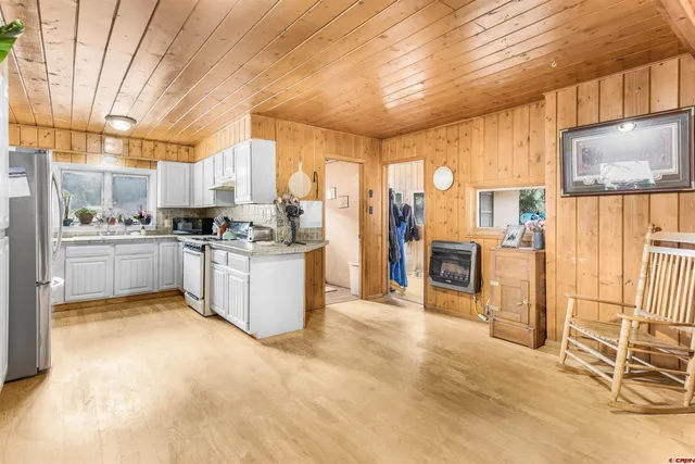 a living room with furniture a flat screen tv and a large window