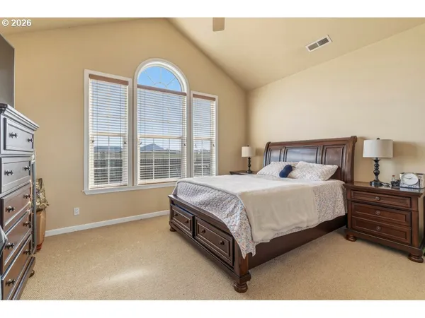 a large bed sitting in a bedroom next to a window