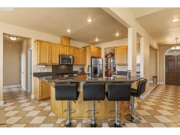 a kitchen with stainless steel appliances kitchen island granite countertop a sink and cabinets
