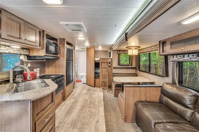 a kitchen with granite countertop a refrigerator stove and microwave