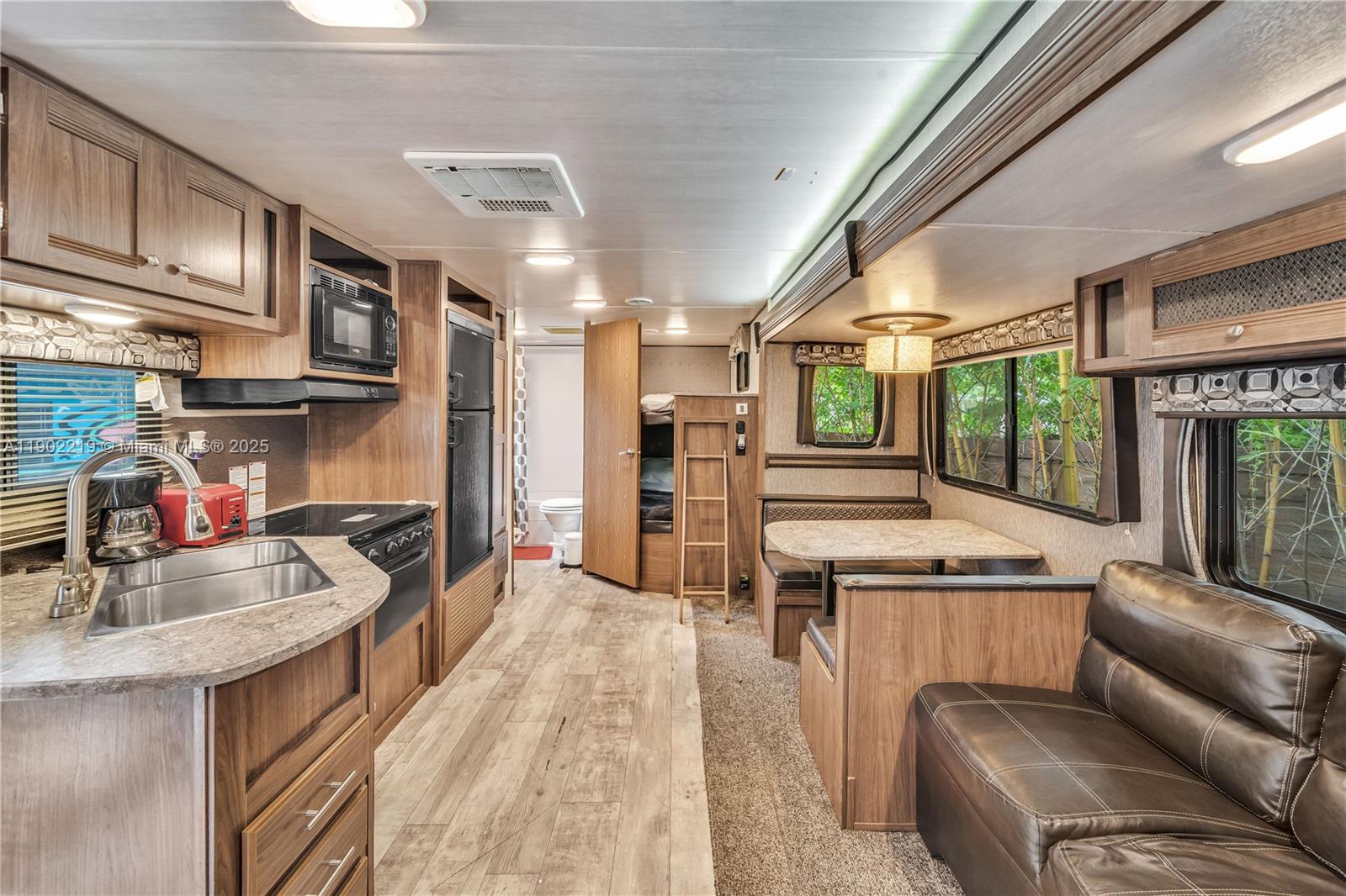 710 Northeast 141st Street North Miami, FL 33161 - Photo 21 of 78 a kitchen with stainless steel appliances granite countertop a sink a stove and a refrigerator