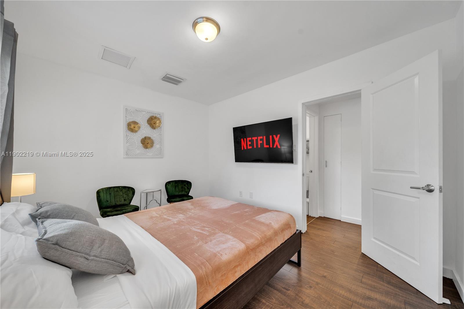 710 Northeast 141st Street North Miami, FL 33161 - Photo 25 of 78 a bedroom with a bed and a painting on the wall