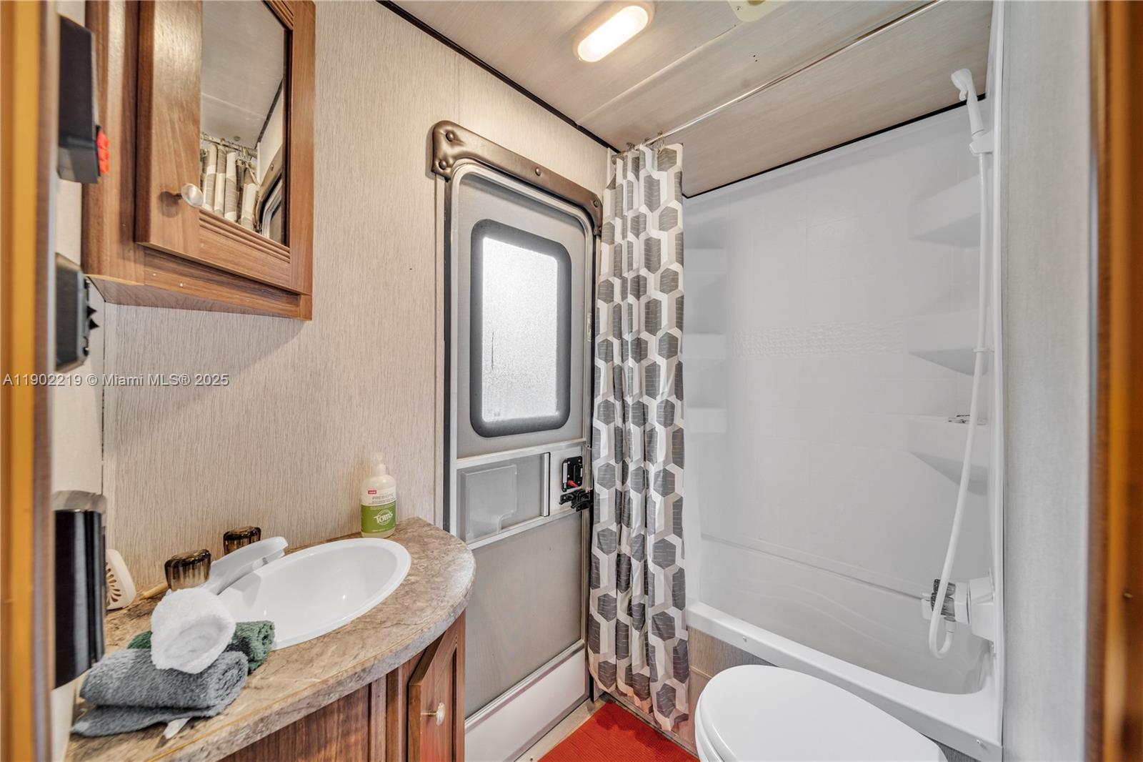 710 Northeast 141st Street North Miami, FL 33161 - Photo 28 of 78 a bathroom with a granite countertop bathtub sink vanity mirror and toilet