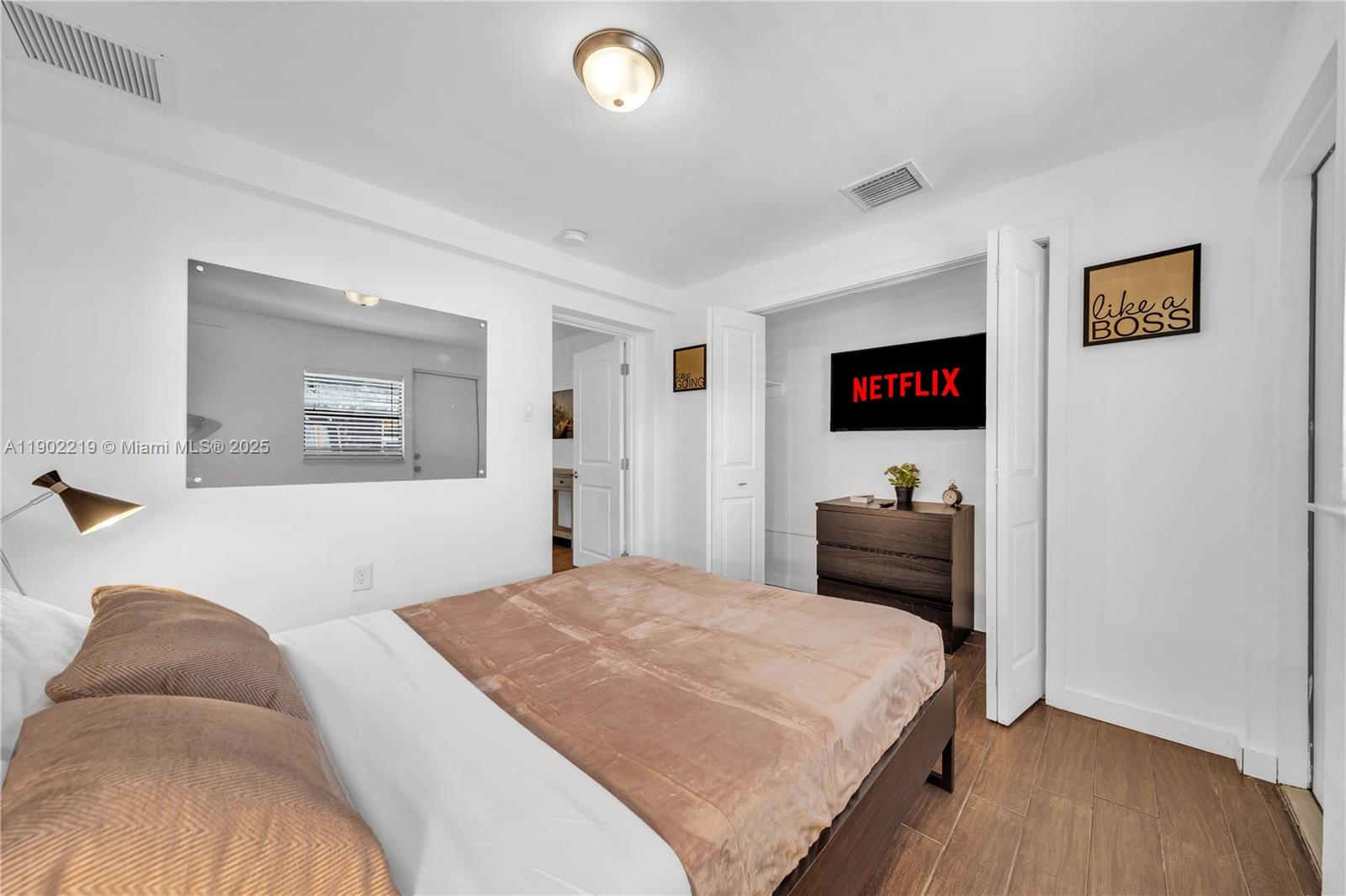 710 Northeast 141st Street North Miami, FL 33161 - Photo 3 of 78 a bedroom with a bed and a large mirror