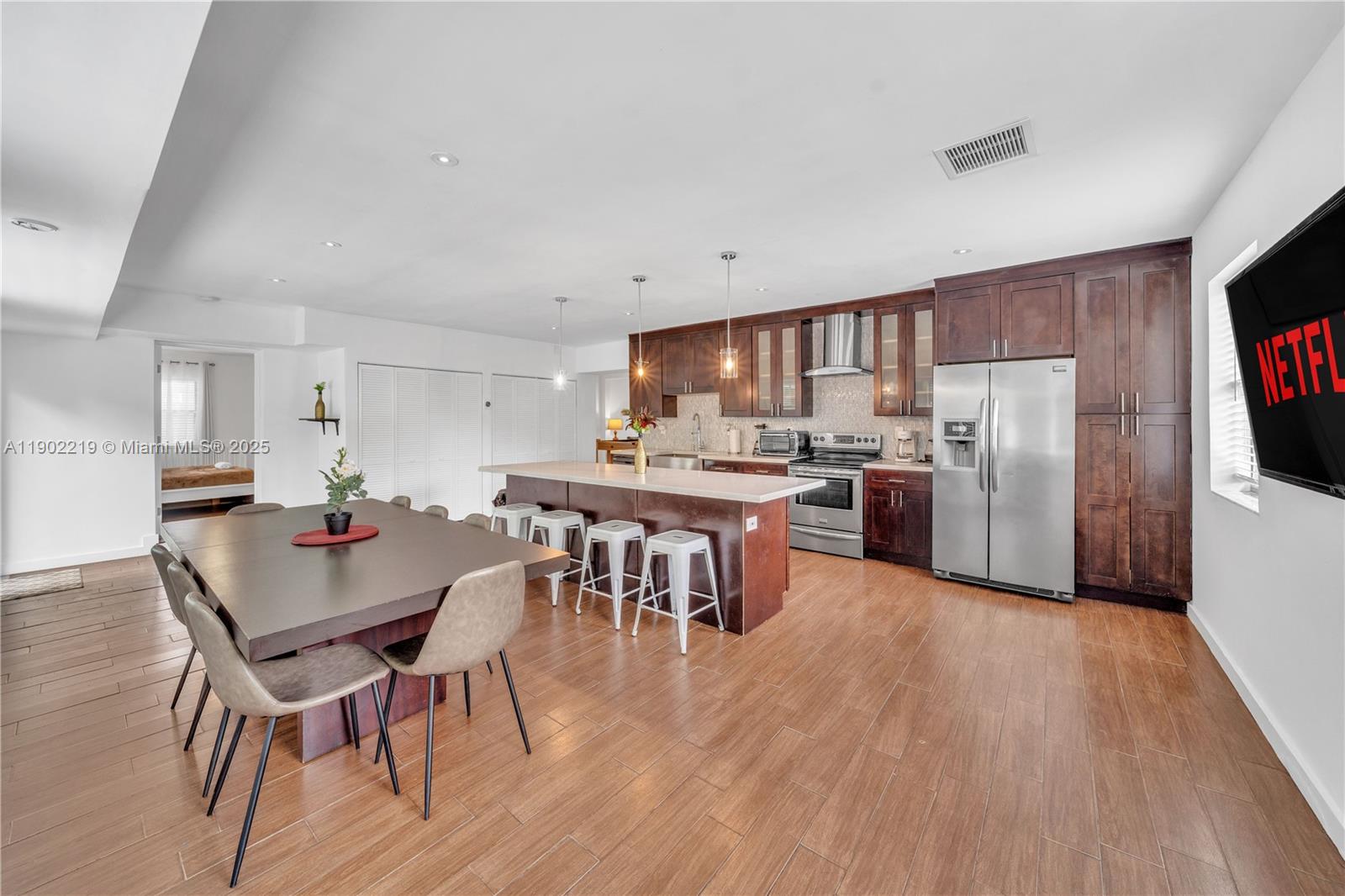 710 Northeast 141st Street North Miami, FL 33161 - Photo 8 of 78 a kitchen with stainless steel appliances a dining table chairs stove refrigerator and cabinets