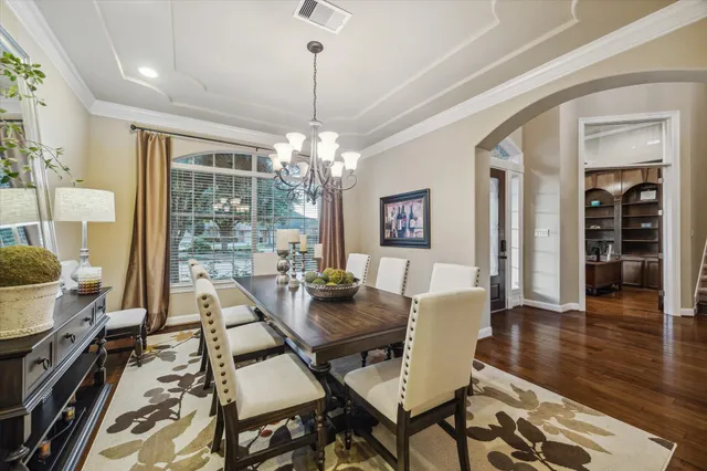 a view of a dining room with furniture wooden floor and chandelier