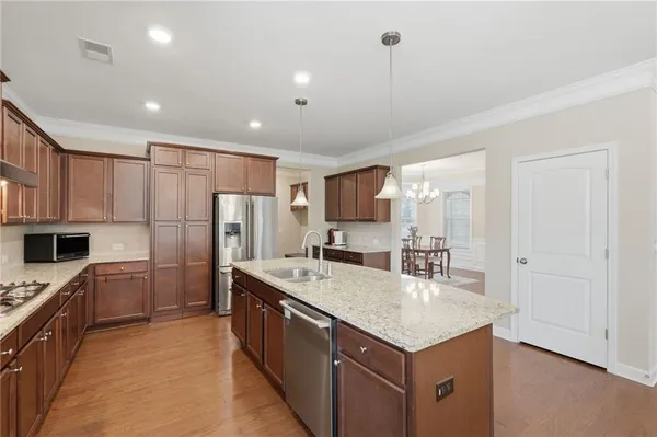 a kitchen with stainless steel appliances granite countertop a sink stove and refrigerator