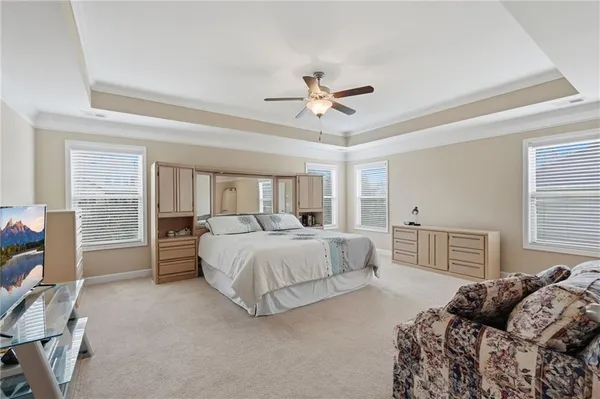 a bedroom with a large bed and a chandelier