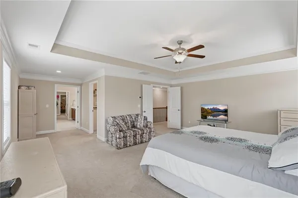 a spacious bedroom with a bed and a chandelier