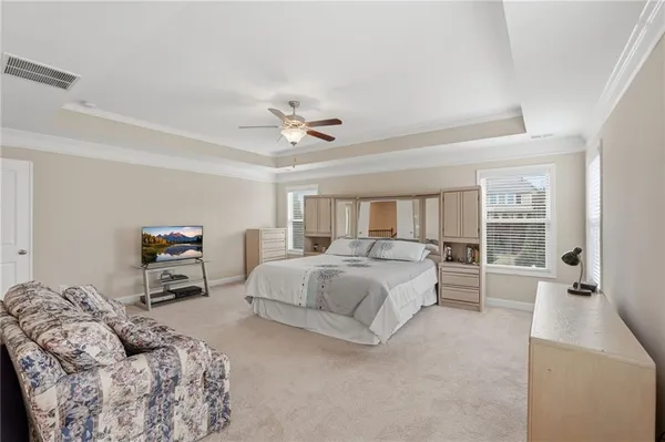 a spacious bedroom with a large bed and a chandelier