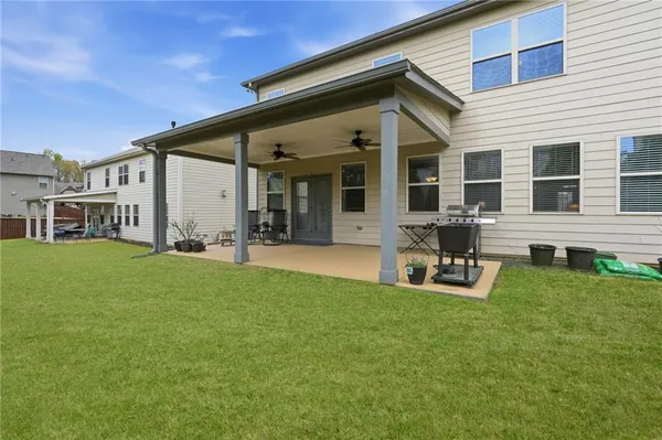 a view of a house with patio and a yard