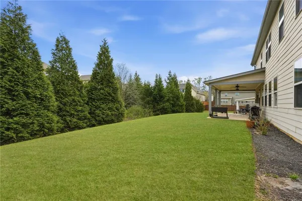 a view of a house with backyard and a trees