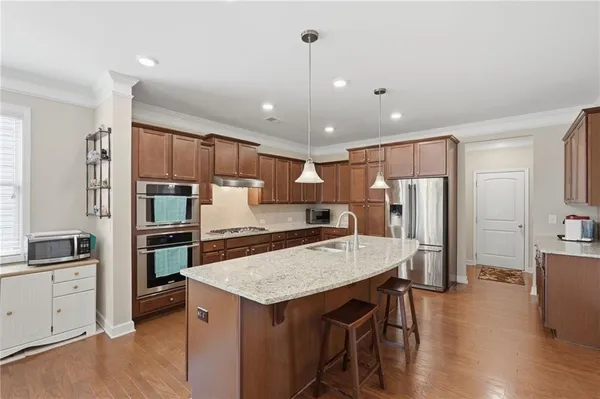 a kitchen with stainless steel appliances a stove refrigerator sink and microwave